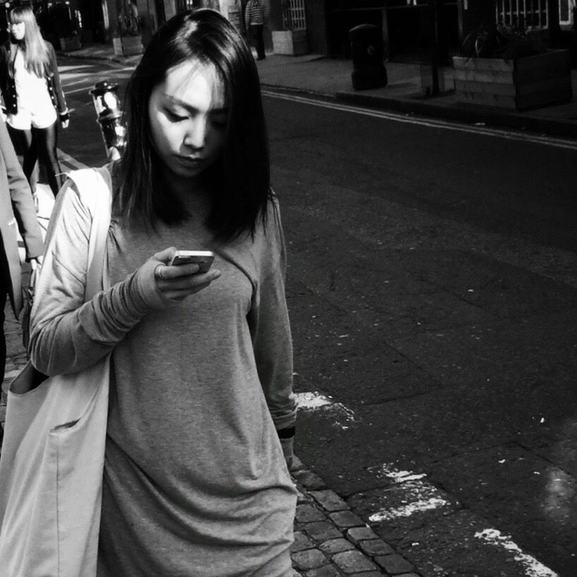 PORTRAIT OF YOUNG WOMAN LOOKING AWAY WHILE STANDING ON ROAD