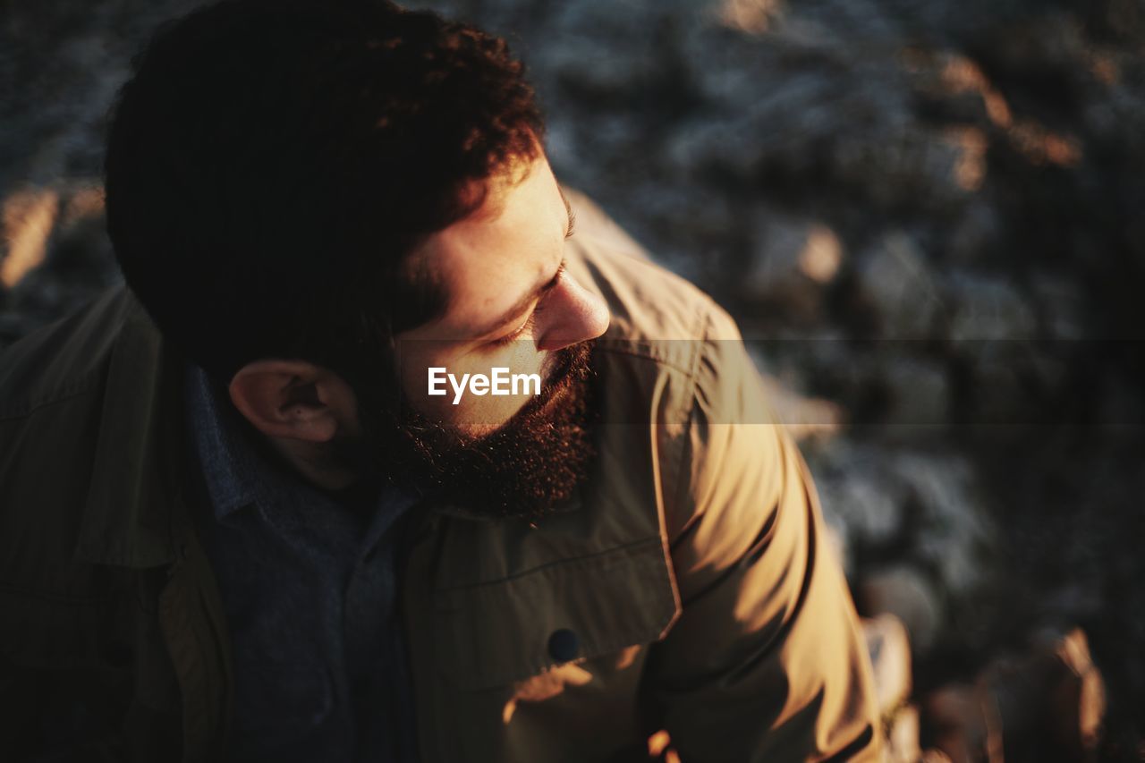 High angle view of bearded man looking away during sunset