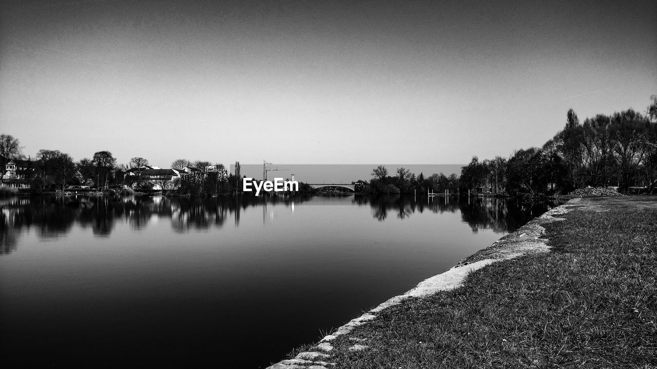 SCENIC VIEW OF LAKE AGAINST SKY AT SUNSET