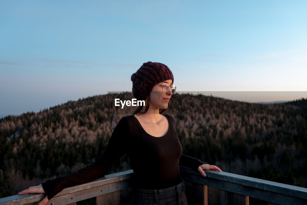 Young woman looking at view against sky