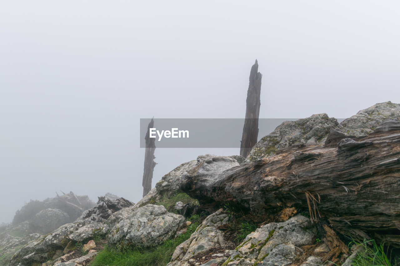 ROCK FORMATIONS BY MOUNTAIN AGAINST SKY