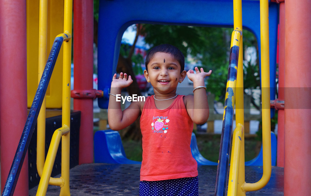 PORTRAIT OF HAPPY BOY PLAYING IN PLAYGROUND