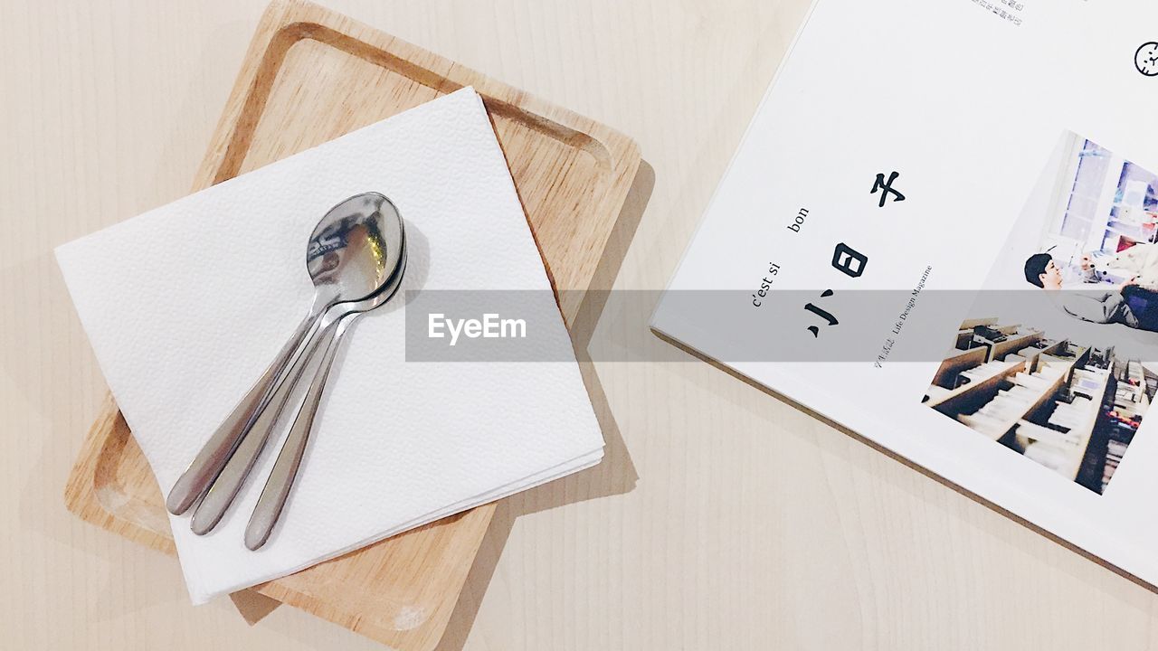 HIGH ANGLE VIEW OF PAPER AND TABLE ON TILED FLOOR