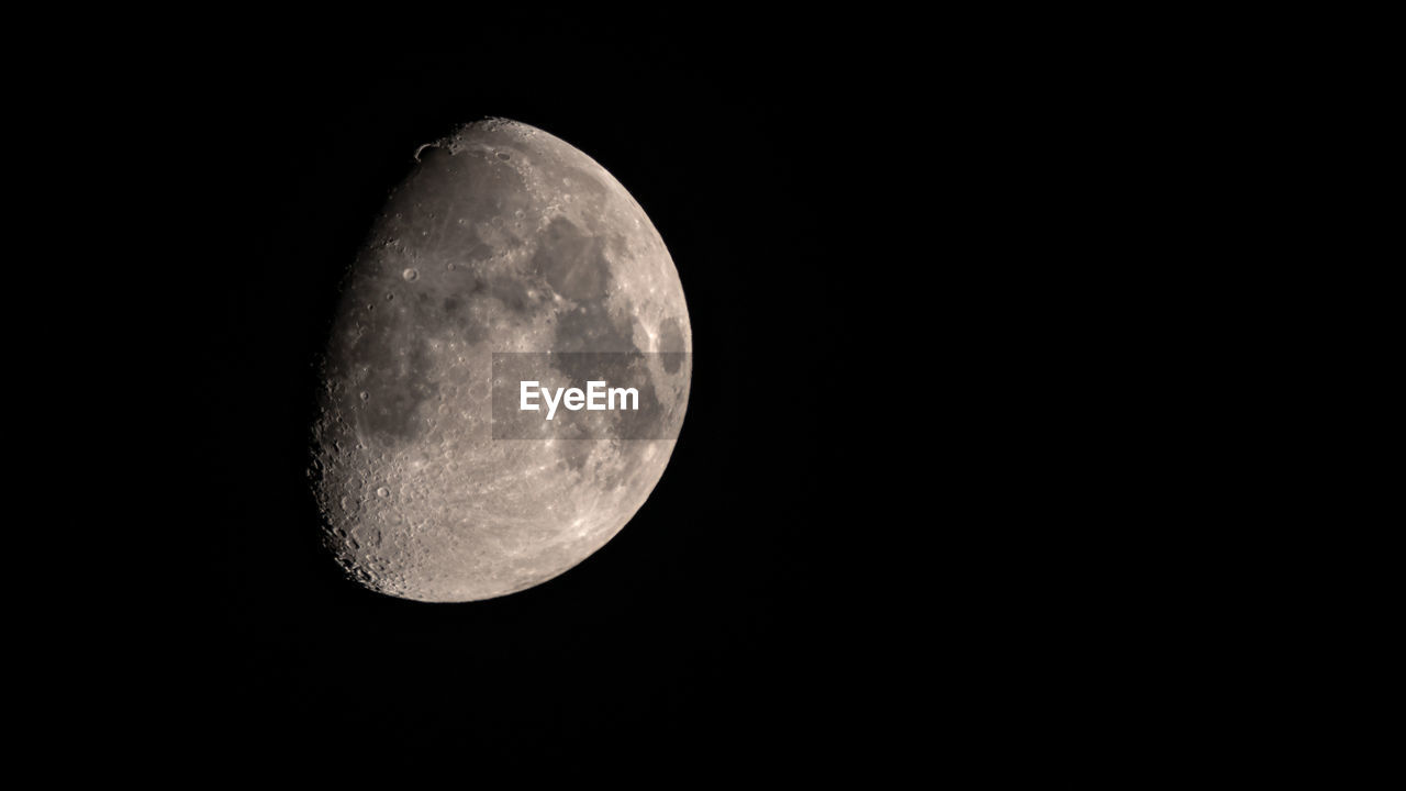 low angle view of moon in mid-air against black background
