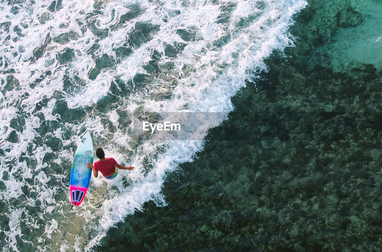 High angle view of man with surfboard in sea