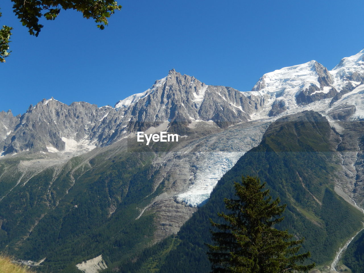 Scenic view of snowcapped mountains against clear blue sky
