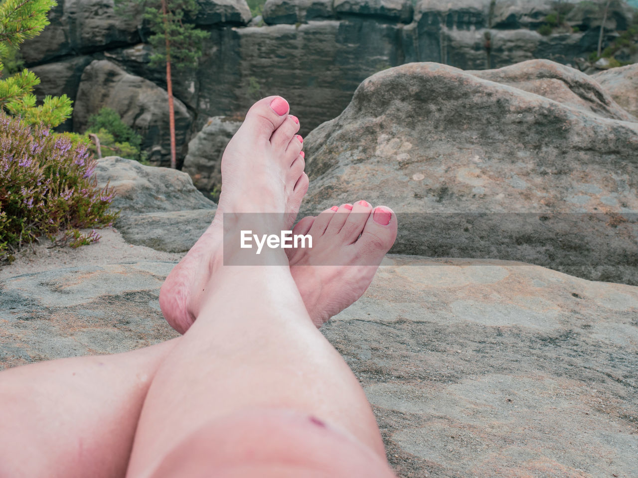 low section, human leg, one person, barefoot, personal perspective, leisure activity, relaxation, lifestyles, nature, human foot, adult, rock, women, water, day, limb, vacation, trip, holiday, human limb, land, toe, resting, beach, outdoors, high angle view, beauty in nature, summer, tranquility, legs crossed at ankle, plant