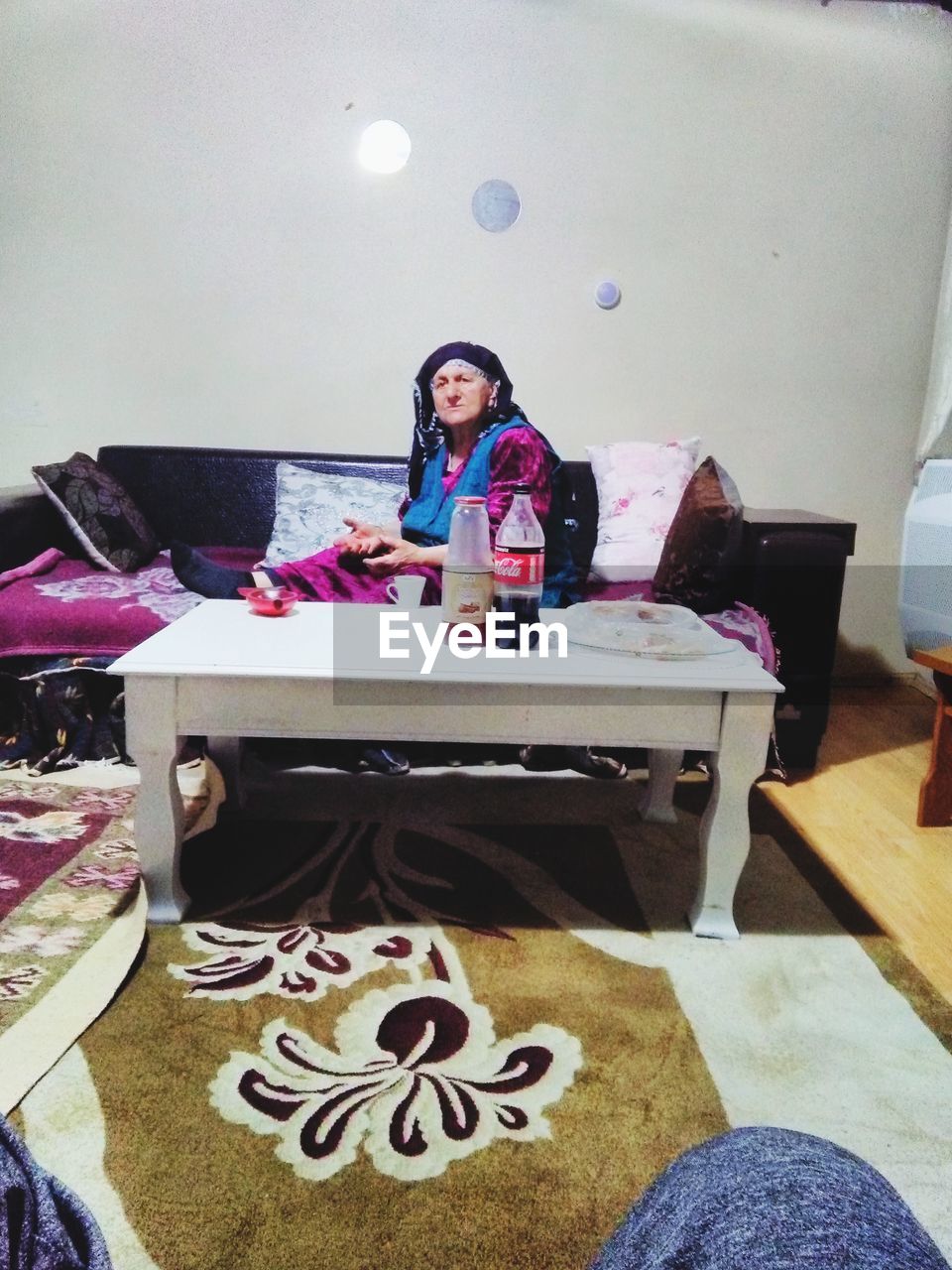 PORTRAIT OF YOUNG WOMAN SITTING ON TABLE AT HOME