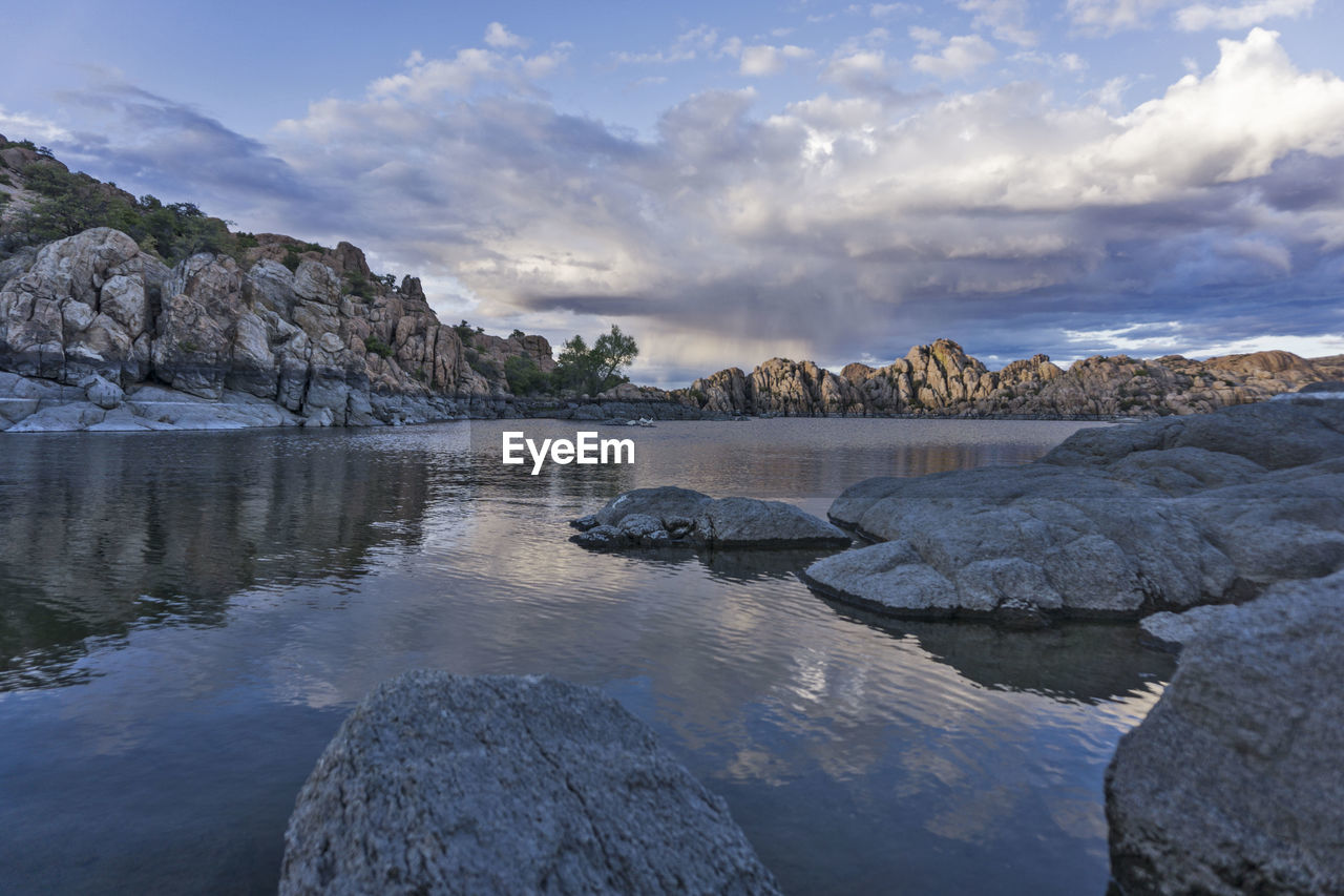 Scenic view of river by rocks against sky