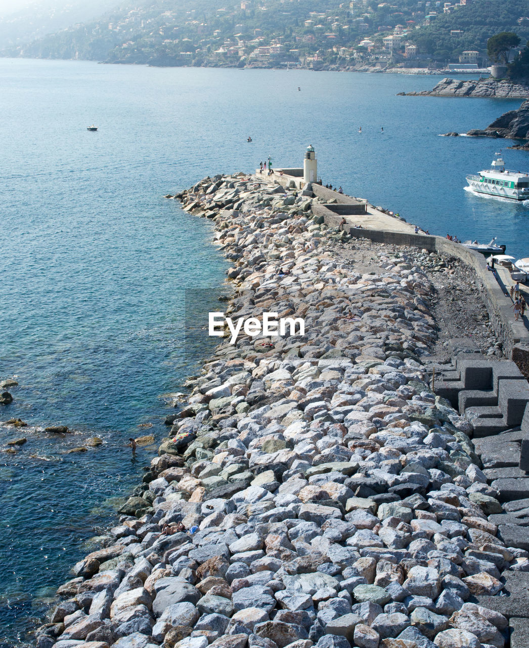 Pier of the touristic harbor of the sea village of camogli, liguria, italy that faces paradise bay