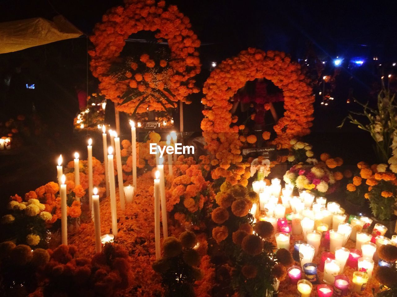 High angle view of food with illuminated candles and flowers during day of the dead festival