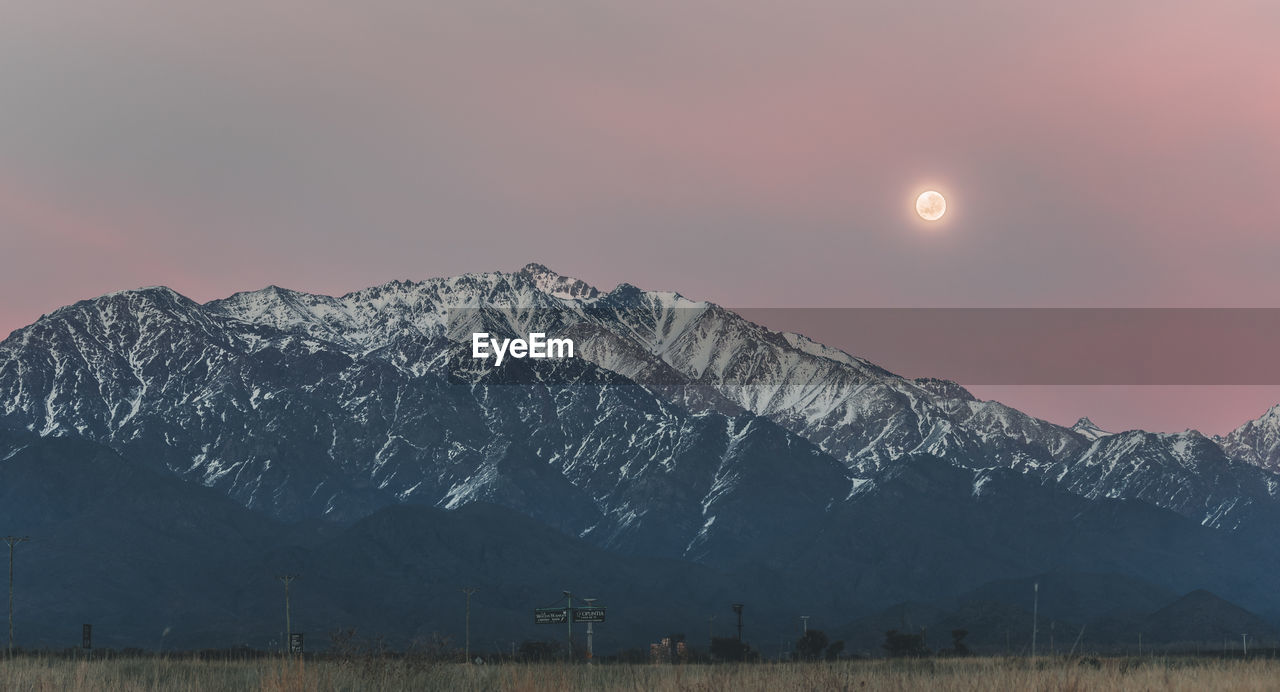 View of the snowy mountain range in the andes with the first lights of