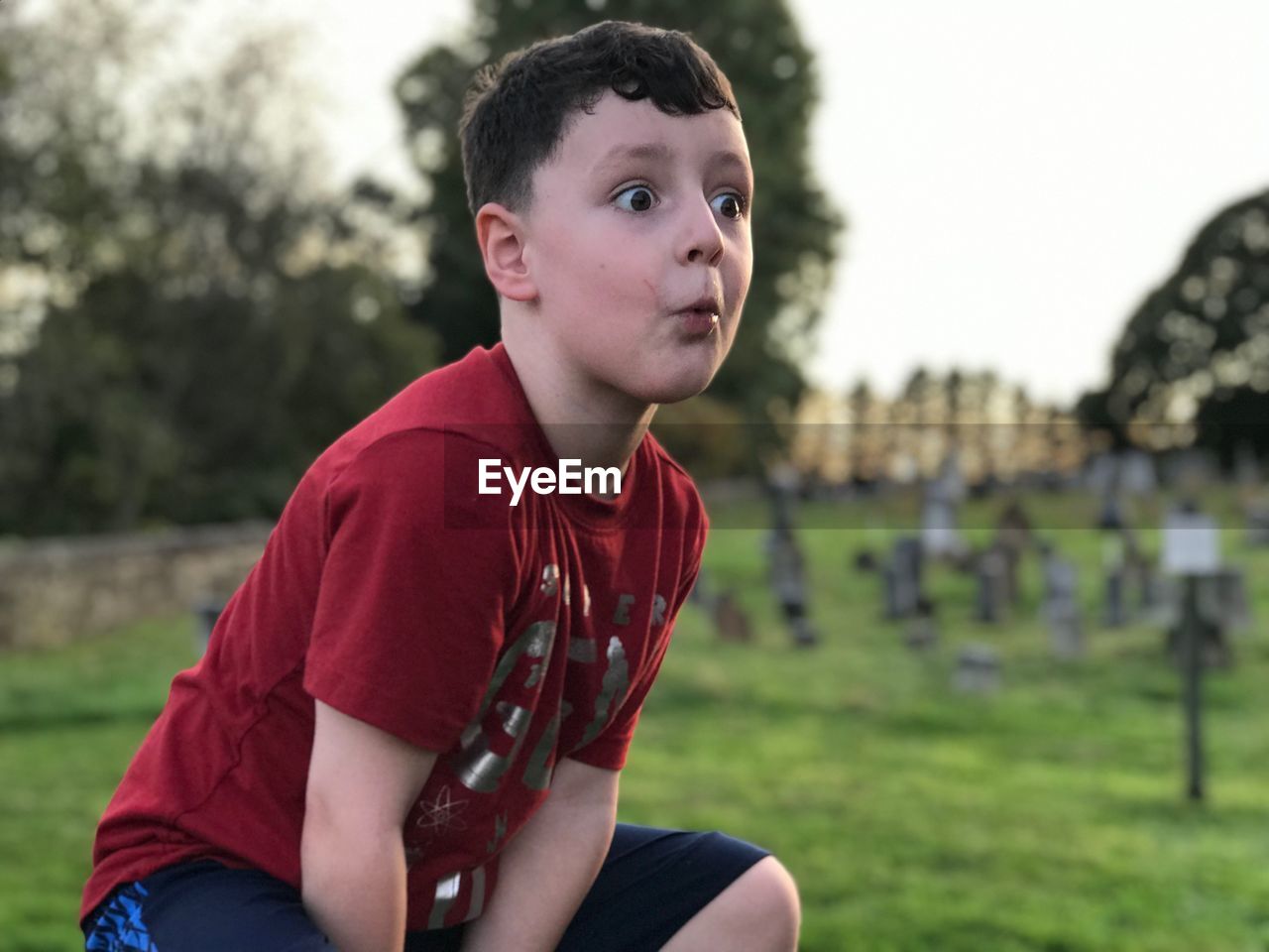 Shocked boy crouching on field