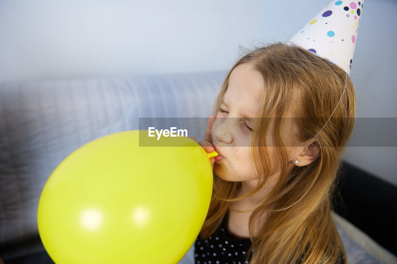 Children have fun playing, blowing up colorful balloons, at a birthday party