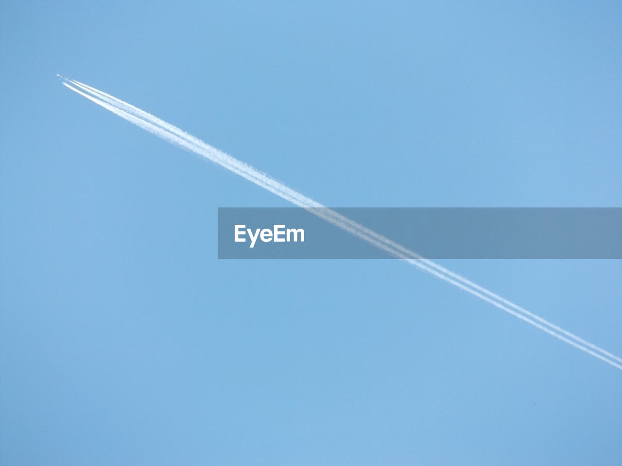 Low angle view of contrail at blue sky