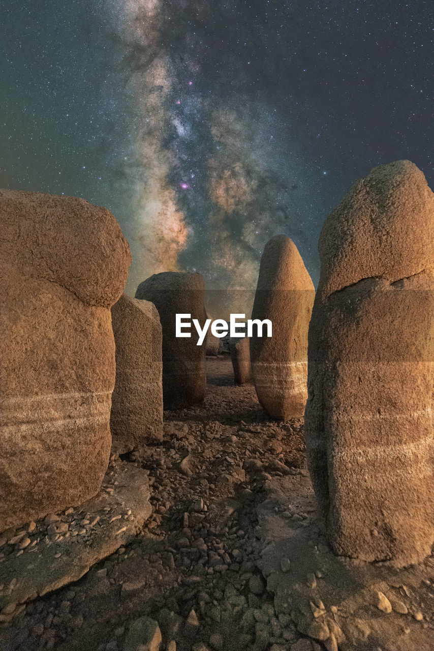 Picturesque view of spanish stonehenge on rough terrain under sunset sky with galaxy in caceres spain