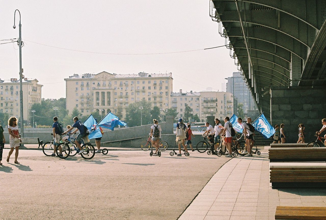 PEOPLE WALKING ON STREET AGAINST SKY