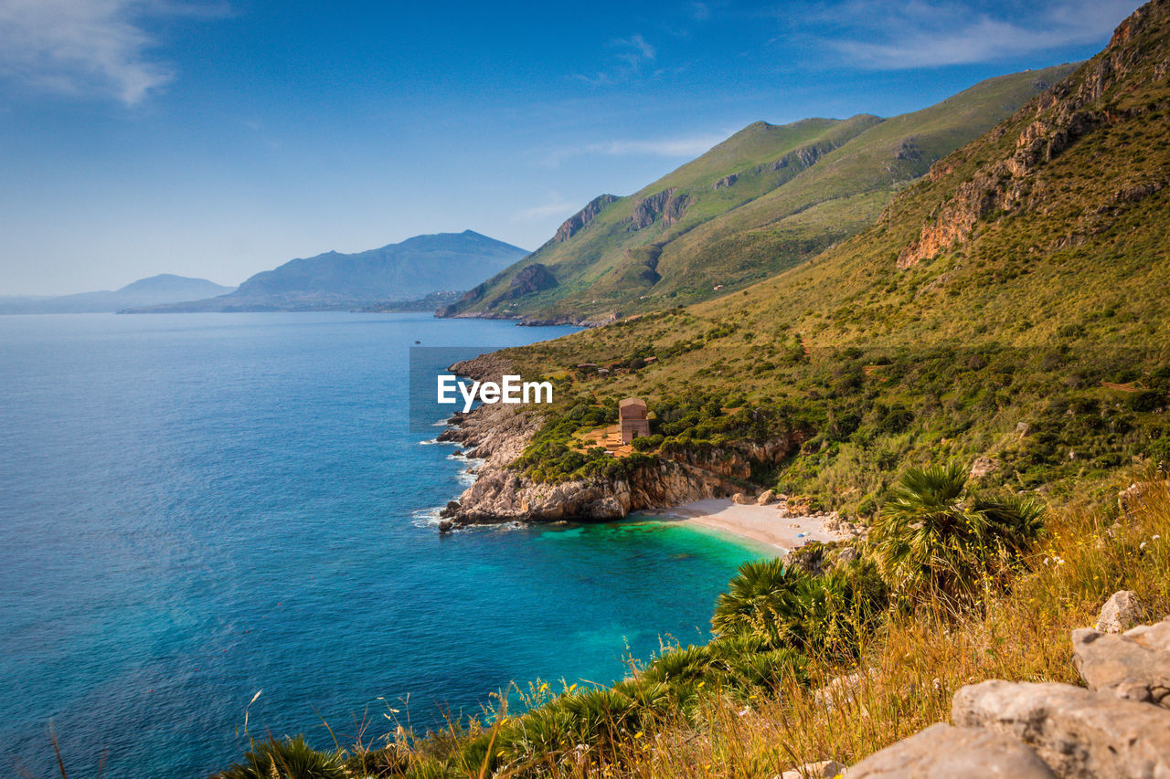 Scenic view of sea and mountains against sky