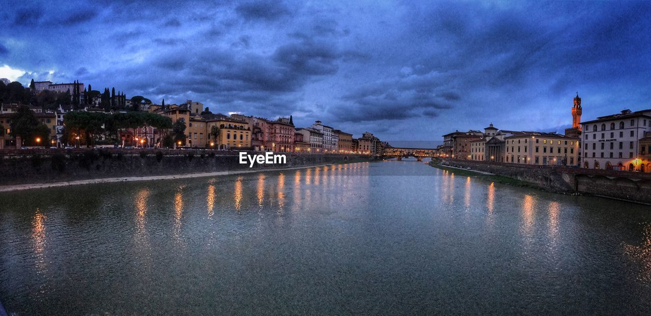 View of river in old town against cloudy sky