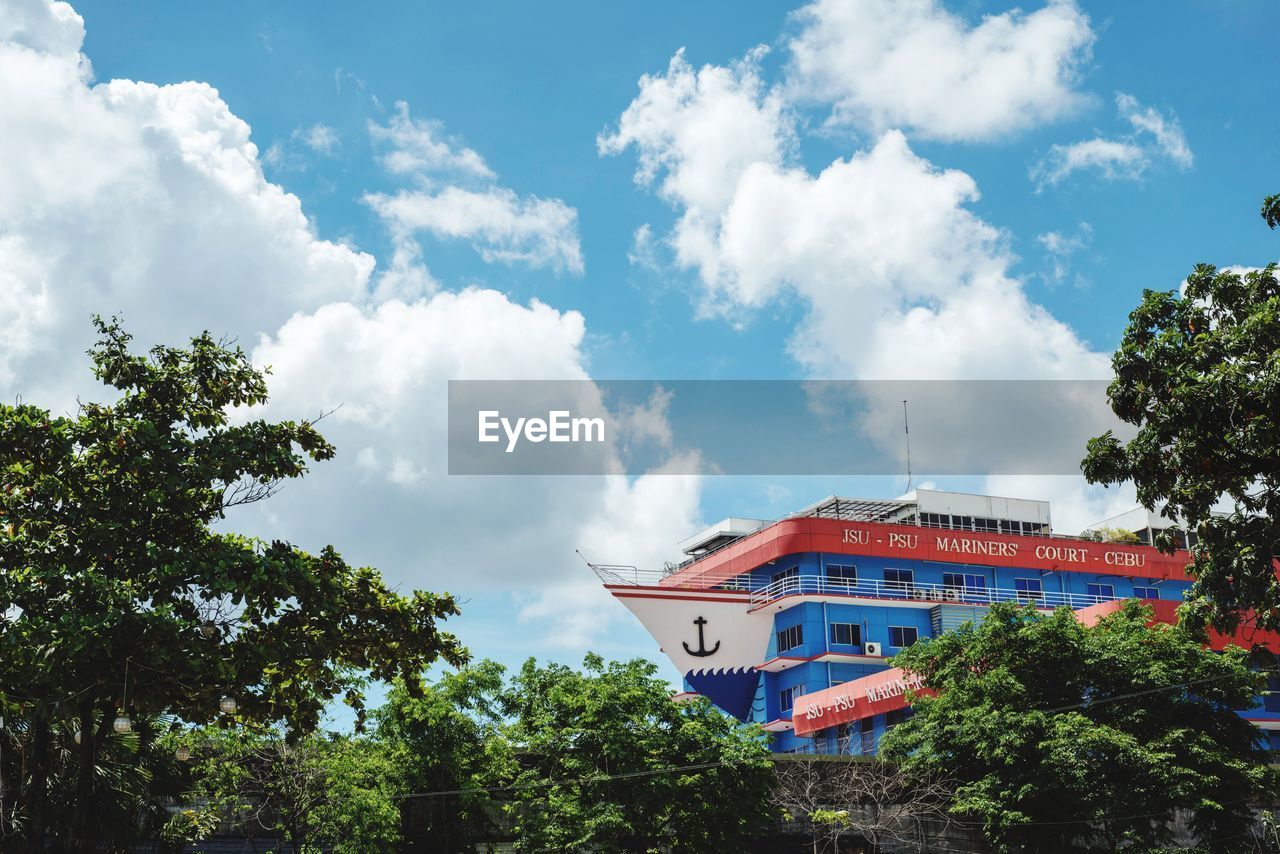 LOW ANGLE VIEW OF BUILDINGS AGAINST CLOUDY SKY