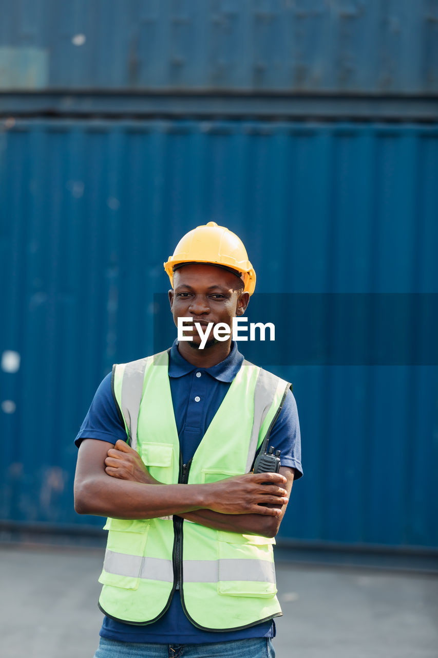 PORTRAIT OF YOUNG MAN WORKING WITH UMBRELLA IN THE BACKGROUND