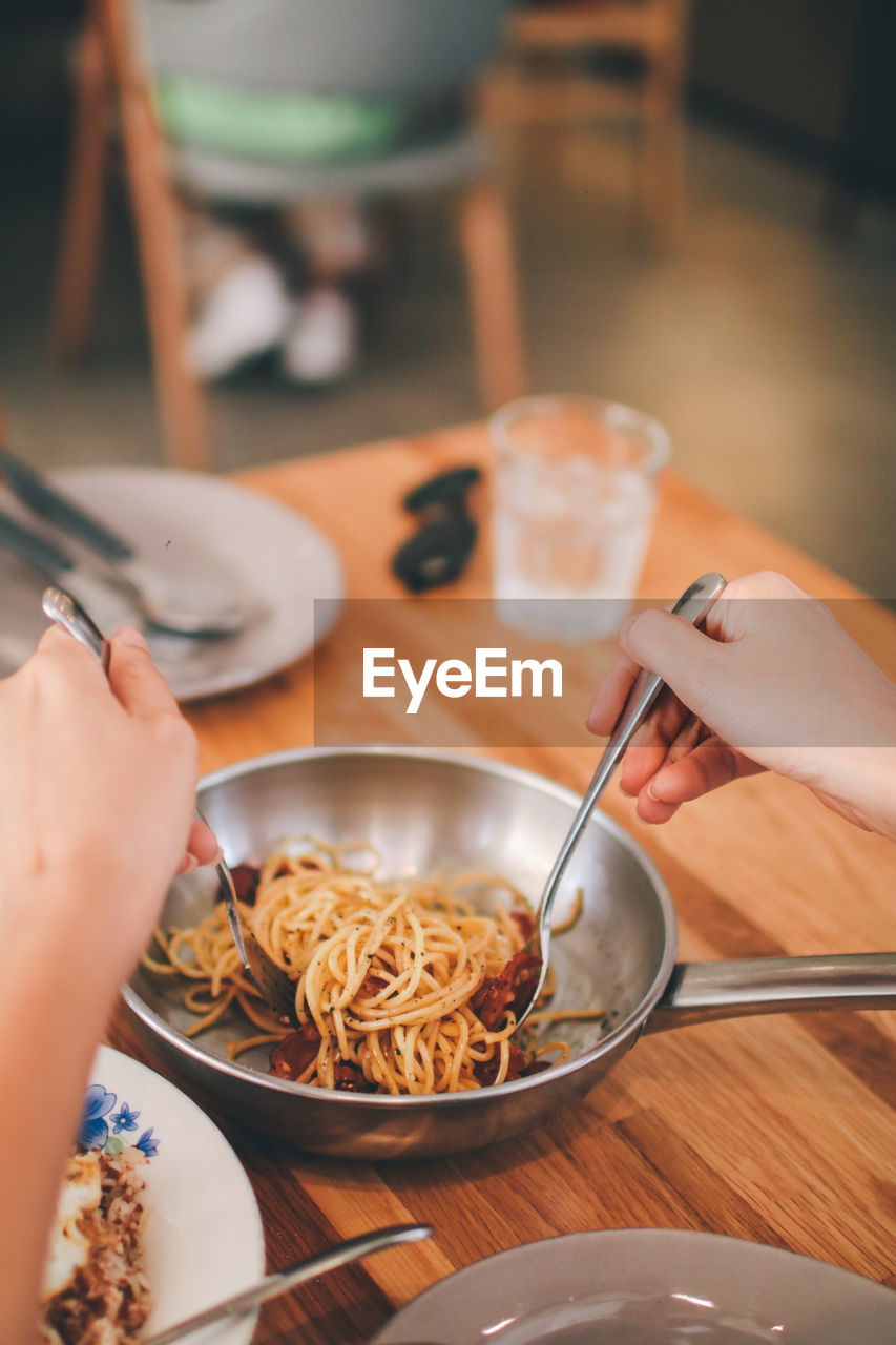 HIGH ANGLE VIEW OF PERSON PREPARING FOOD IN GLASS