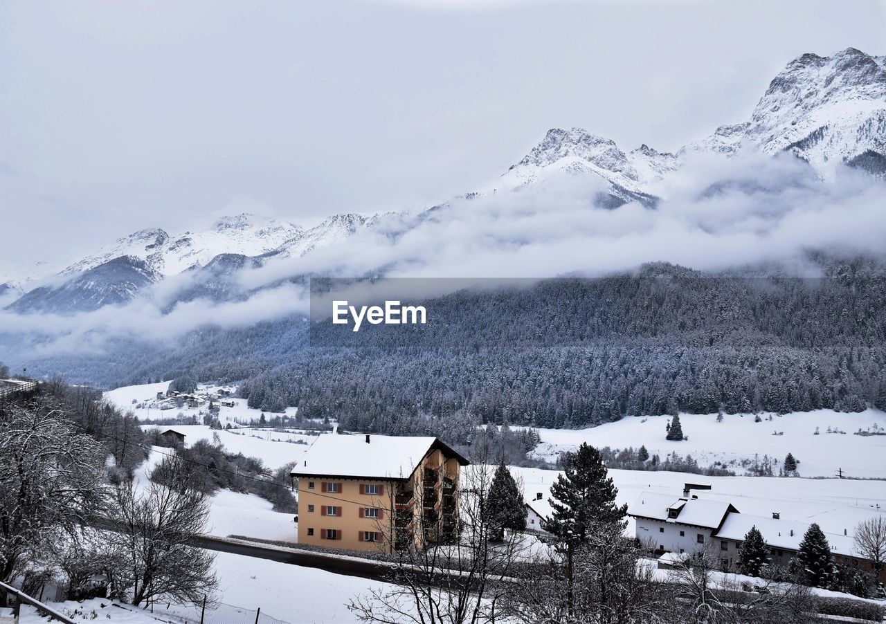 SNOW COVERED HOUSES AGAINST SKY