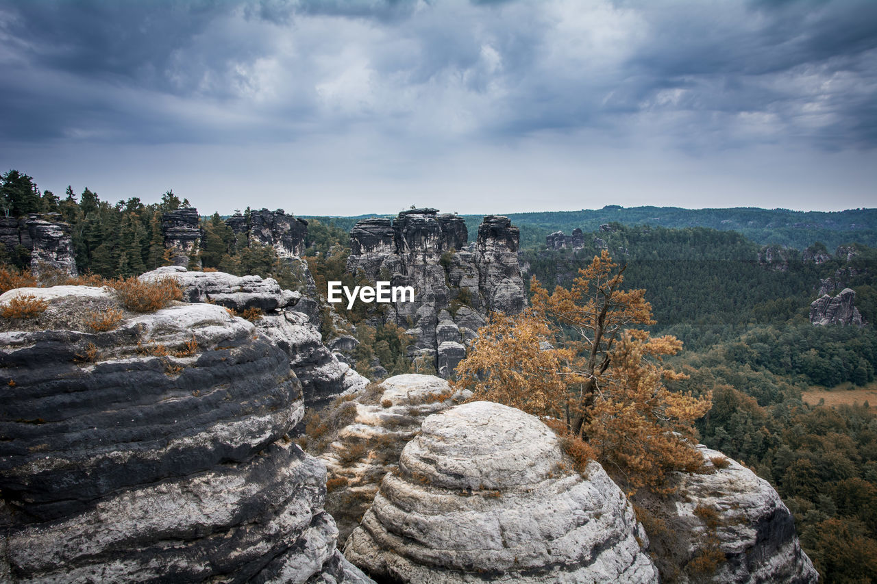 Rock formations against cloudy sky at saxon switzerland