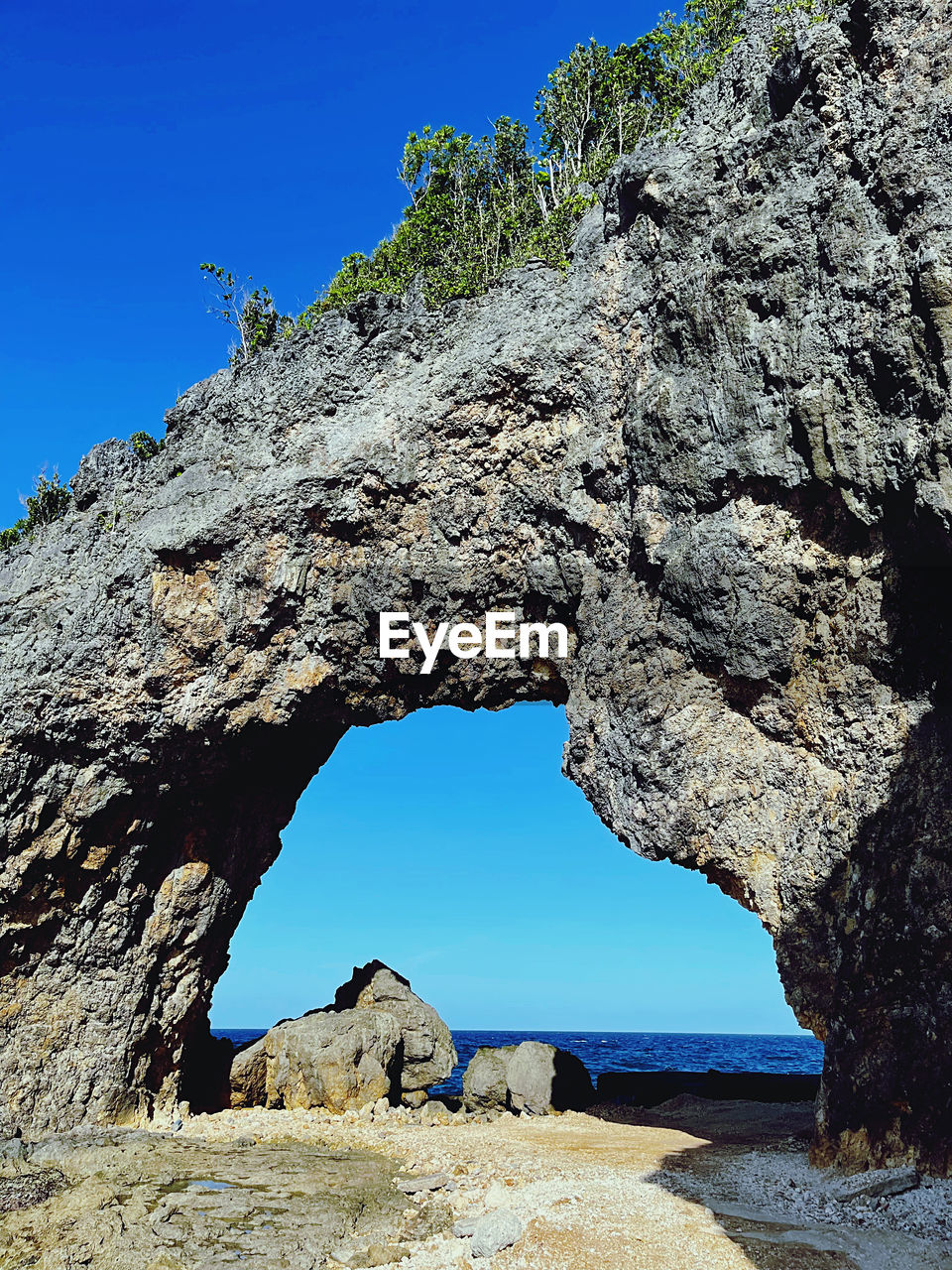 rock, sky, natural arch, clear sky, nature, rock formation, sea, arch, blue, land, beauty in nature, scenics - nature, water, coast, sunny, cave, tranquility, travel destinations, formation, no people, geology, sunlight, architecture, cliff, non-urban scene, travel, environment, physical geography, day, landscape, eroded, outdoors, outdoor pursuit, hole, idyllic, plant, tranquil scene, beach, extreme terrain, terrain, limestone, mountain, tree, history, nature reserve, tourism, ancient history, sea cave, activity, pinaceae