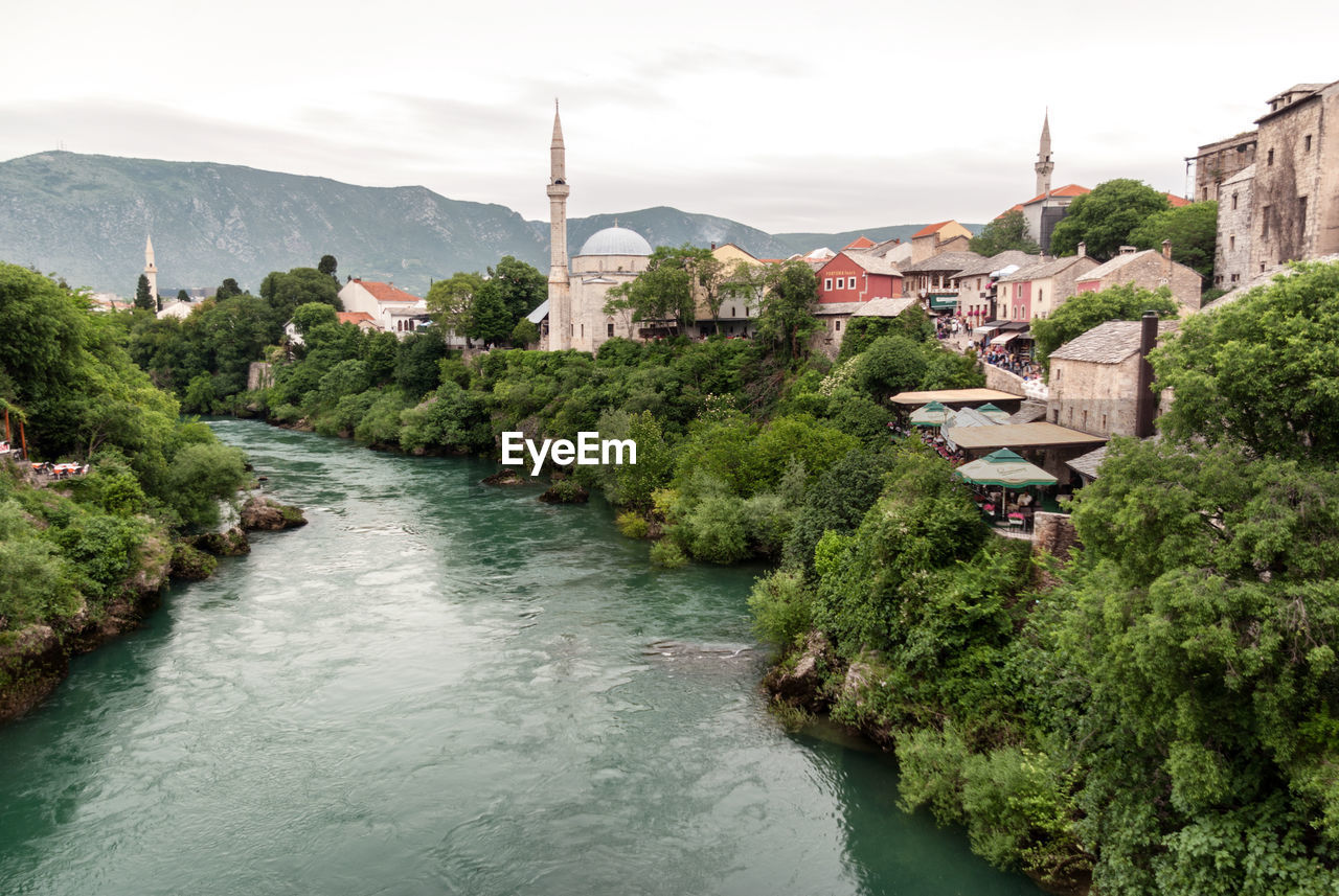 RIVER AMIDST BUILDINGS IN CITY