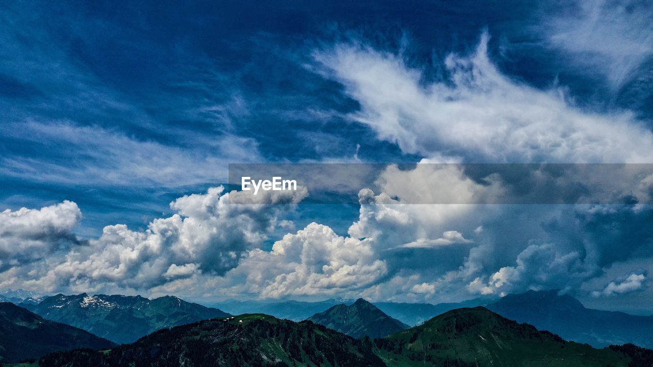 Scenic view of clouds over mountains against sky