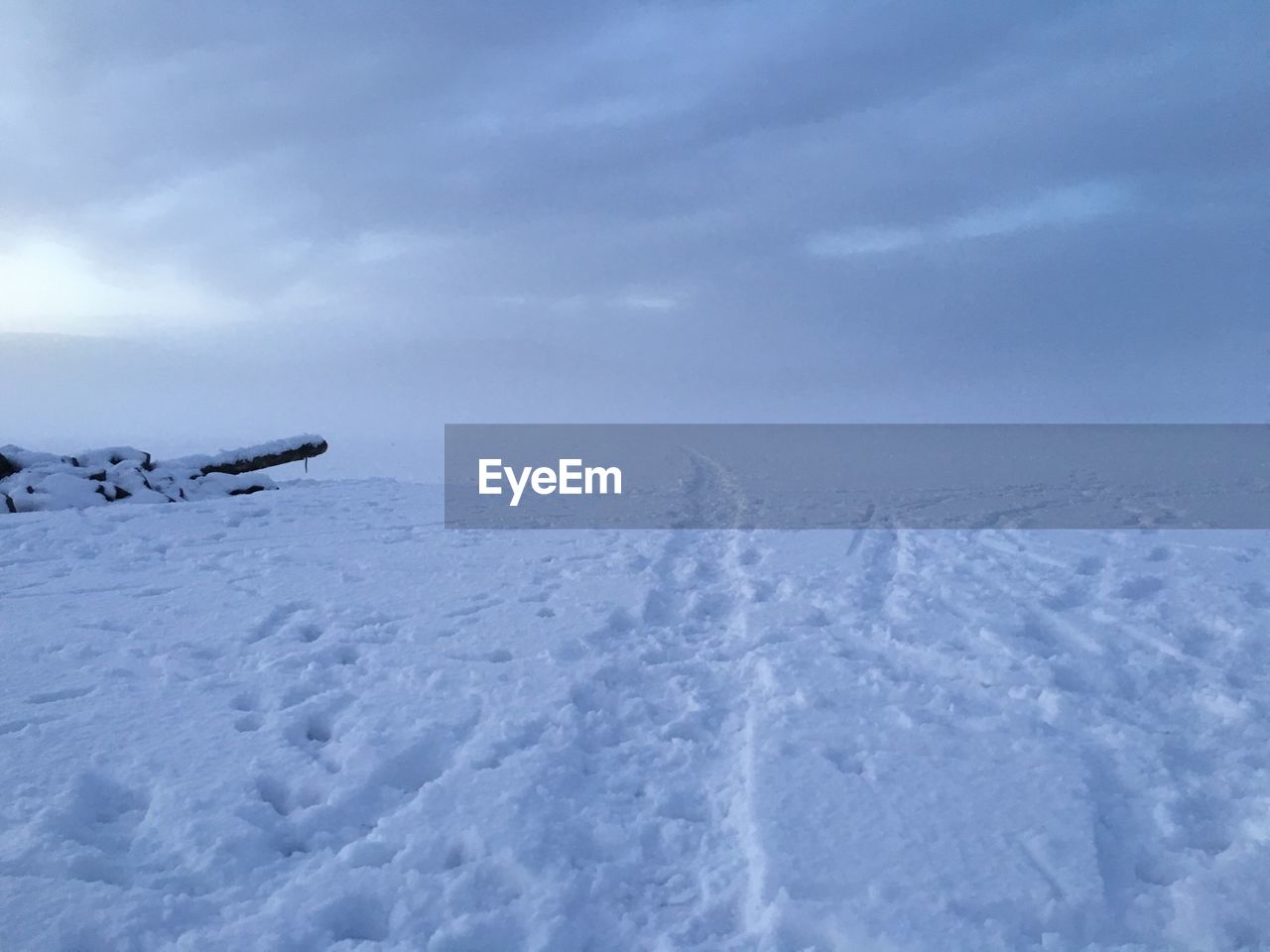 Scenic view of snow covered field against sky