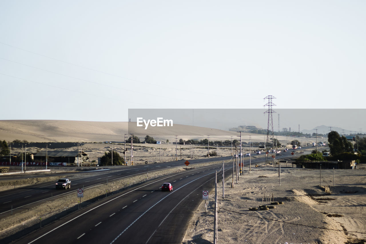 Cars on road against clear sky in the desert 