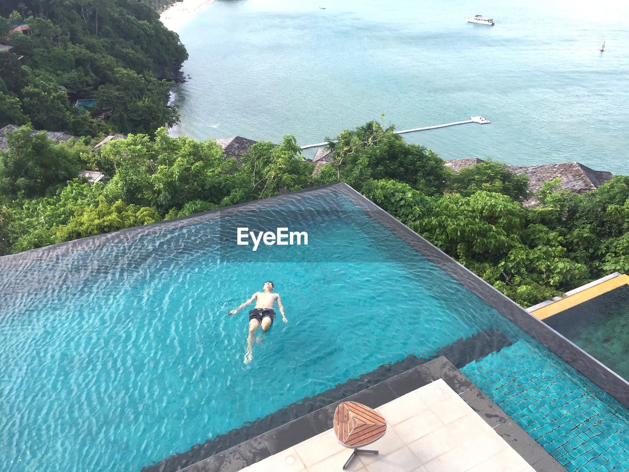 High angle view of man swimming in infinity pool