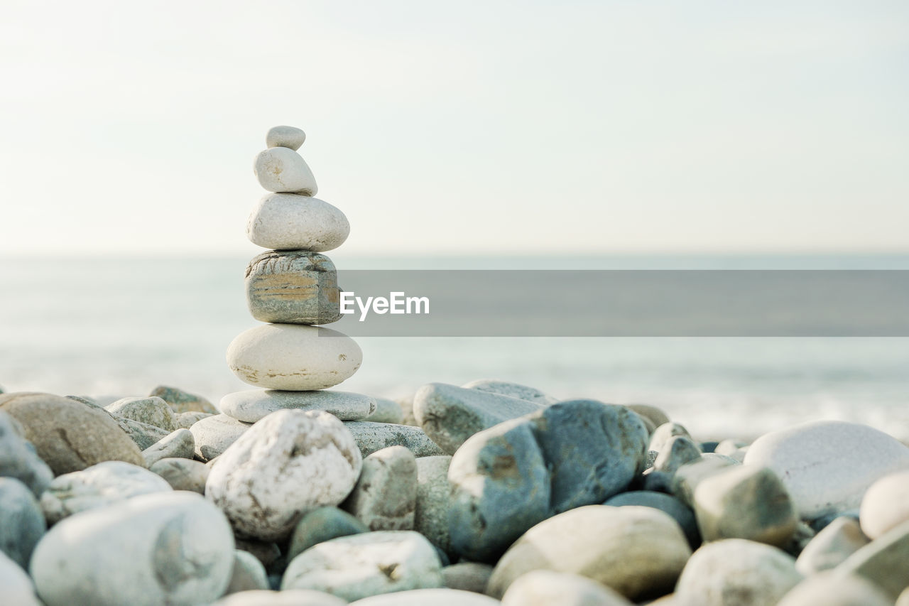Zen pyramid of balanced stones on a background of the sea and blue sky. concept of spiritual harmony