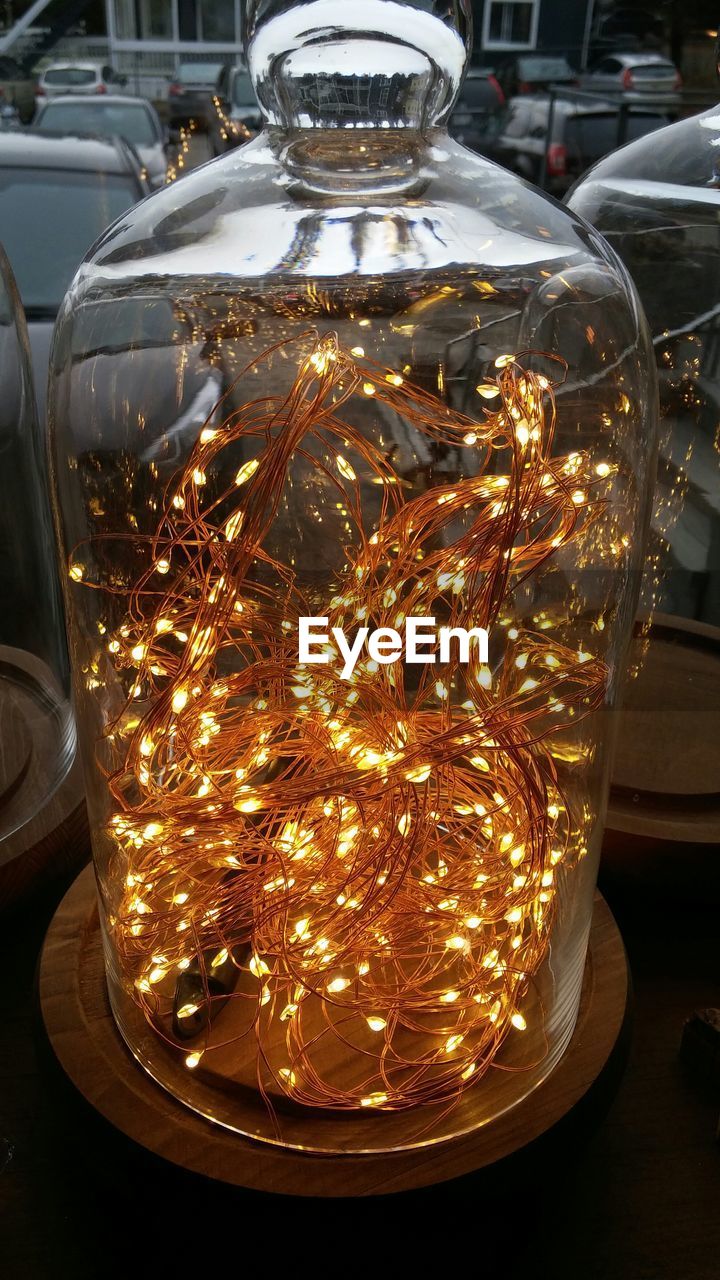 Close-up of illuminated christmas decoration in jar on table