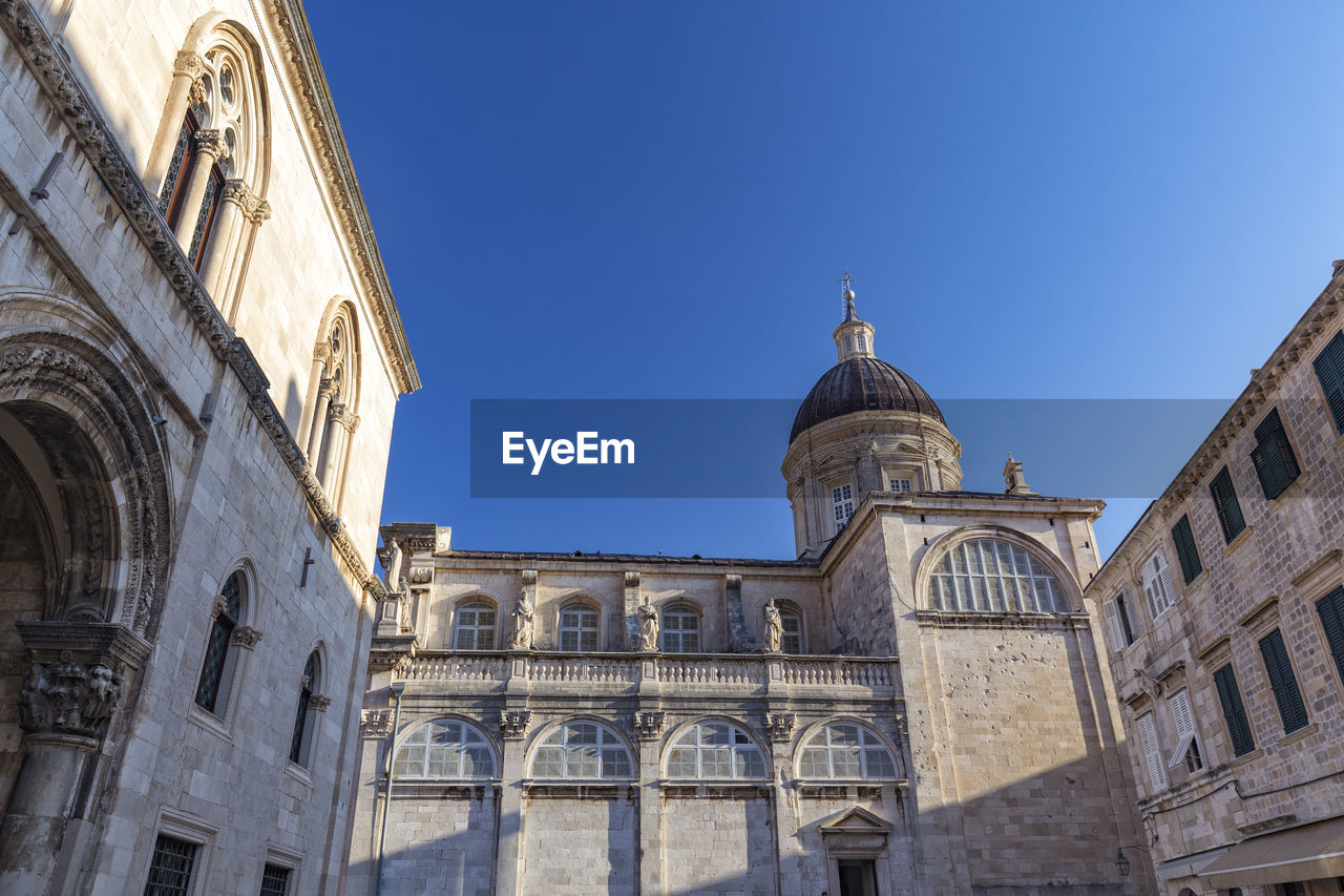 LOW ANGLE VIEW OF BUILDINGS AGAINST BLUE SKY