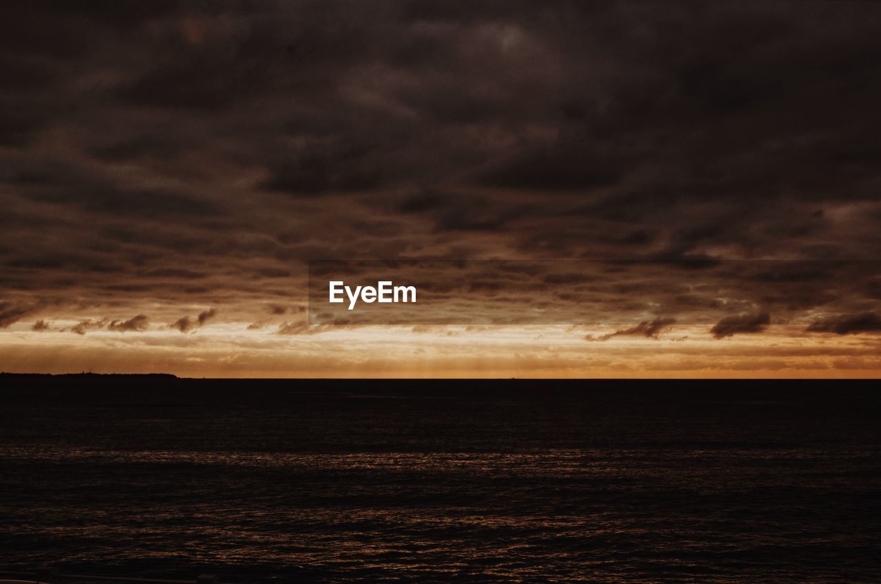 SCENIC VIEW OF SEA AGAINST STORM CLOUDS