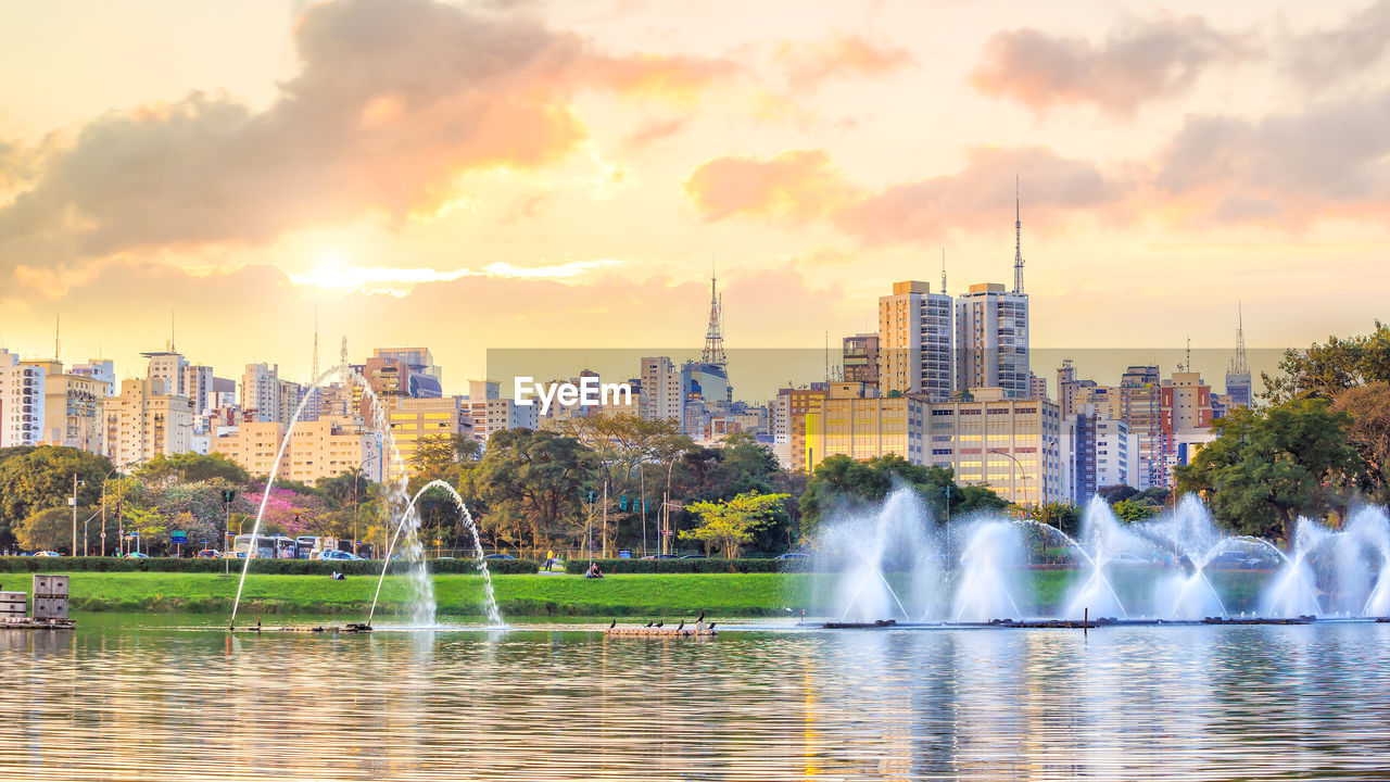 WATER FOUNTAIN IN CITY AGAINST SKY