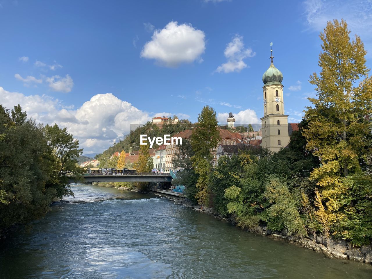 Bridge over river amidst buildings against sky