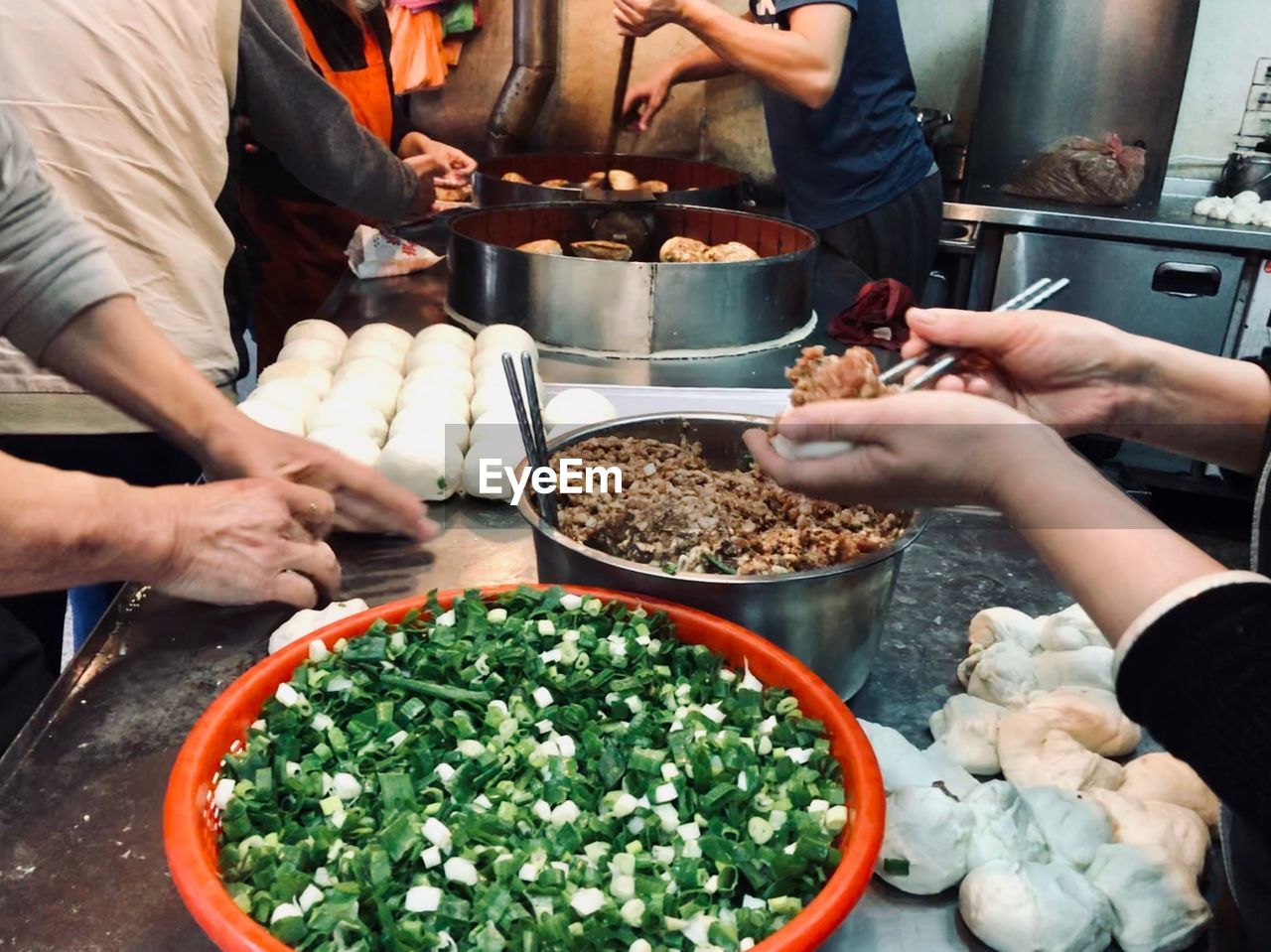 Midsection of men preparing food in commercial kitchen