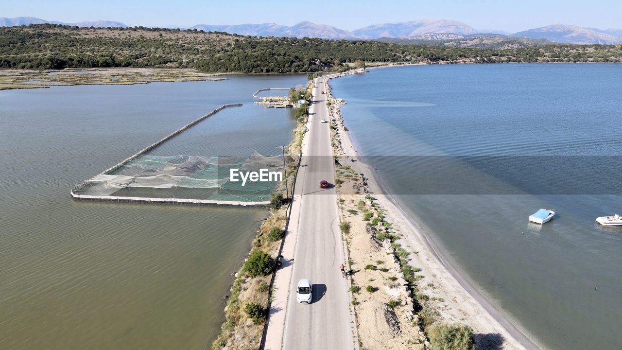 HIGH ANGLE VIEW OF ROAD BY SEA AGAINST SKY