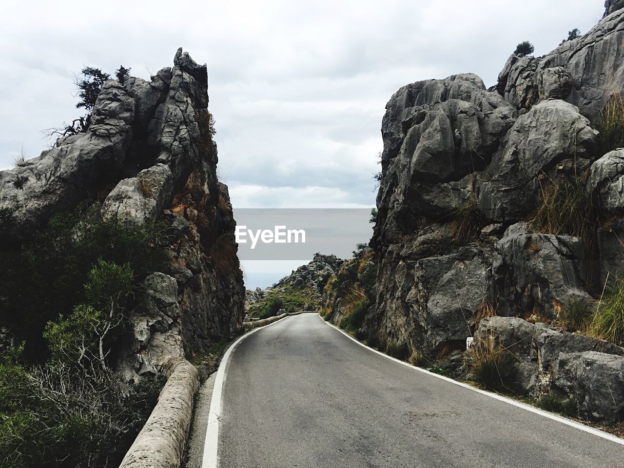 Road amidst rock formation against sky