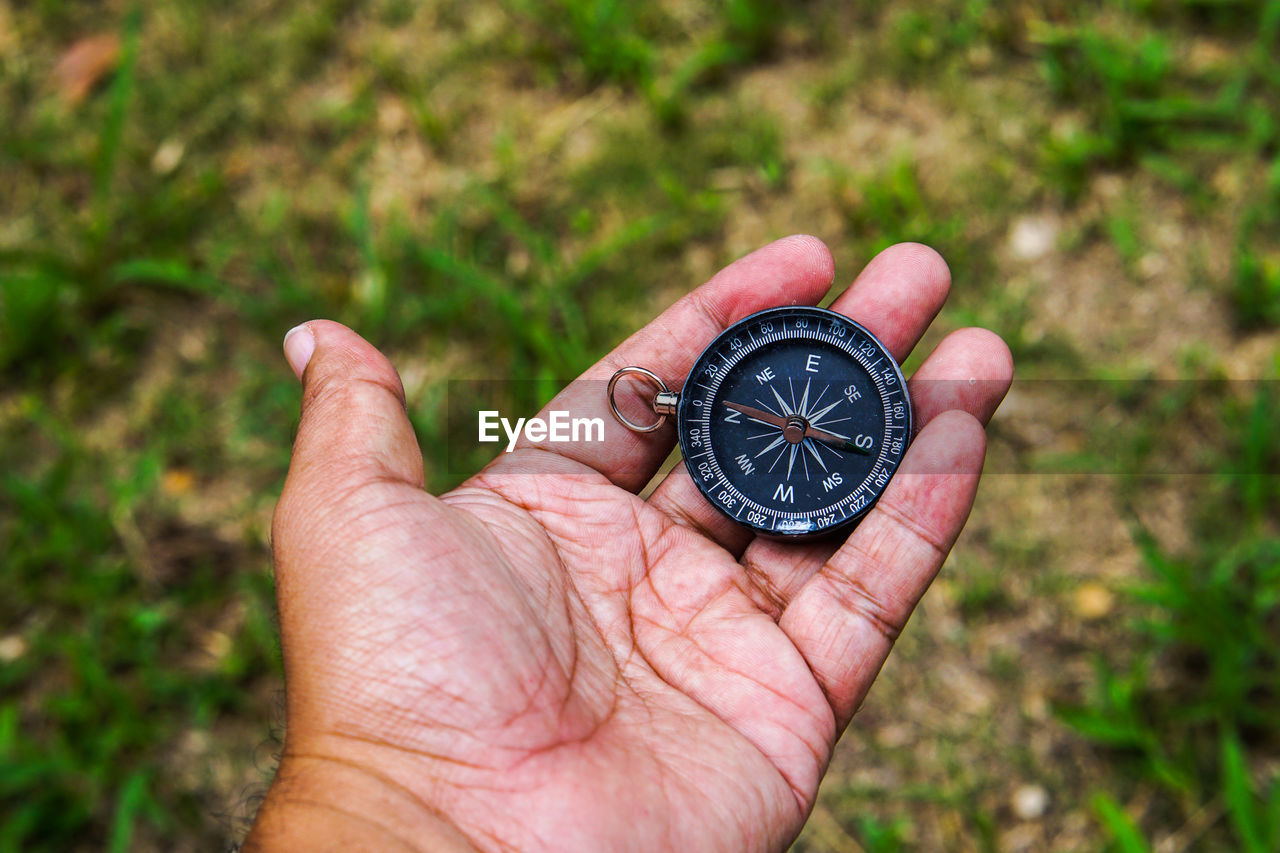 Hand holding black compass