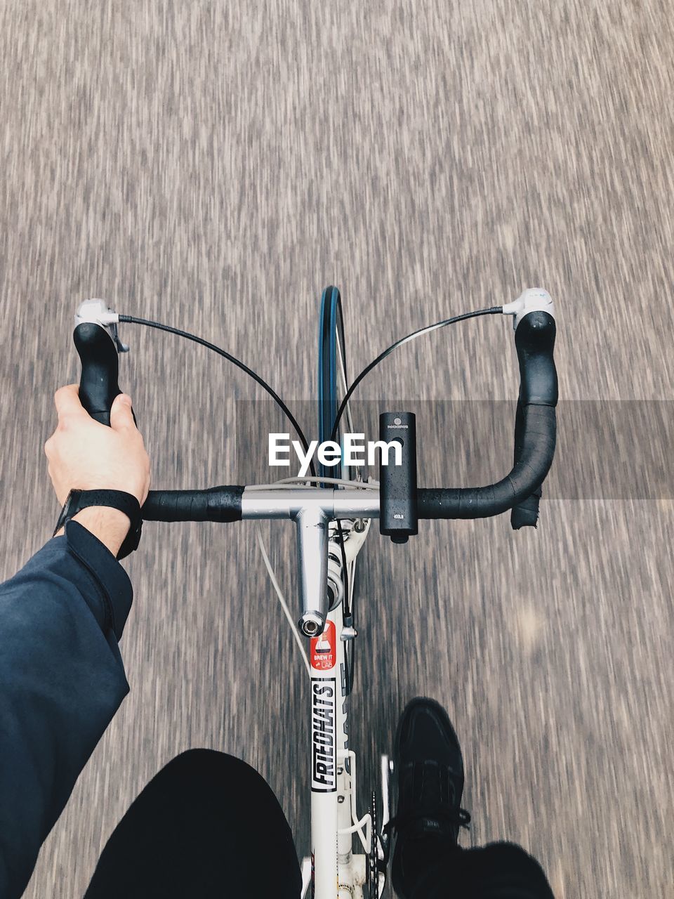 MAN RIDING BICYCLE ON ROAD IN CITY