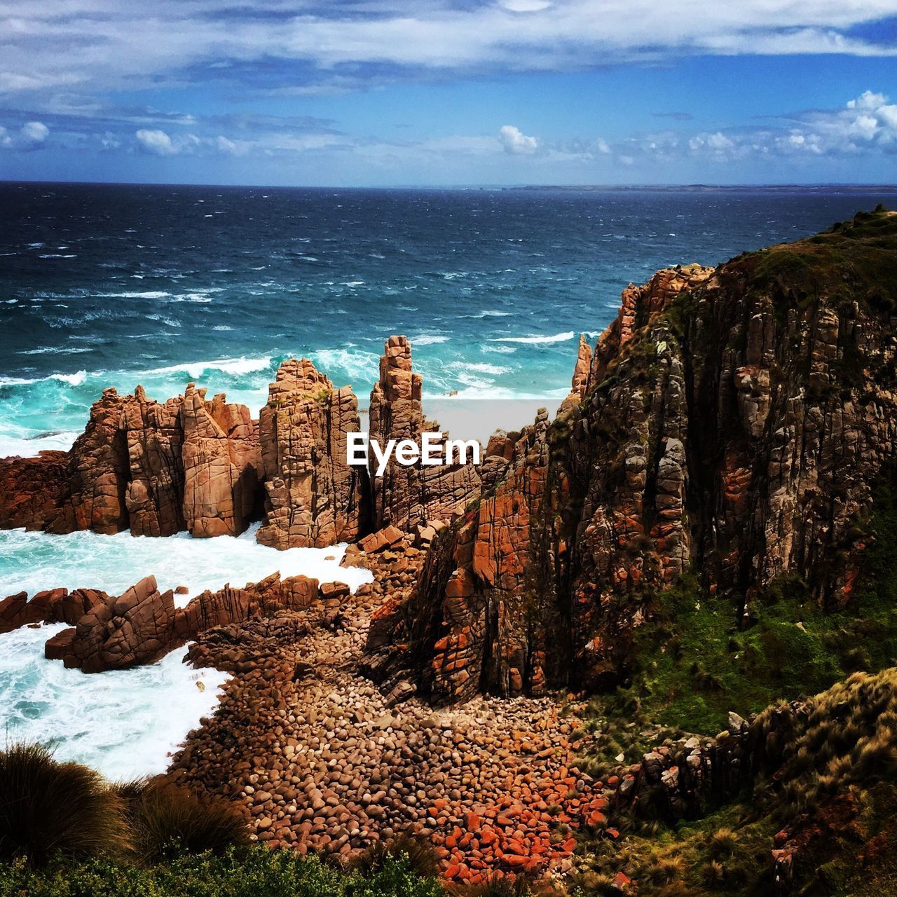 SCENIC VIEW OF SEA BY ROCKS AGAINST SKY