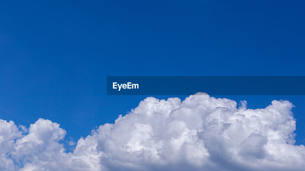 LOW ANGLE VIEW OF WHITE CLOUDS IN BLUE SKY