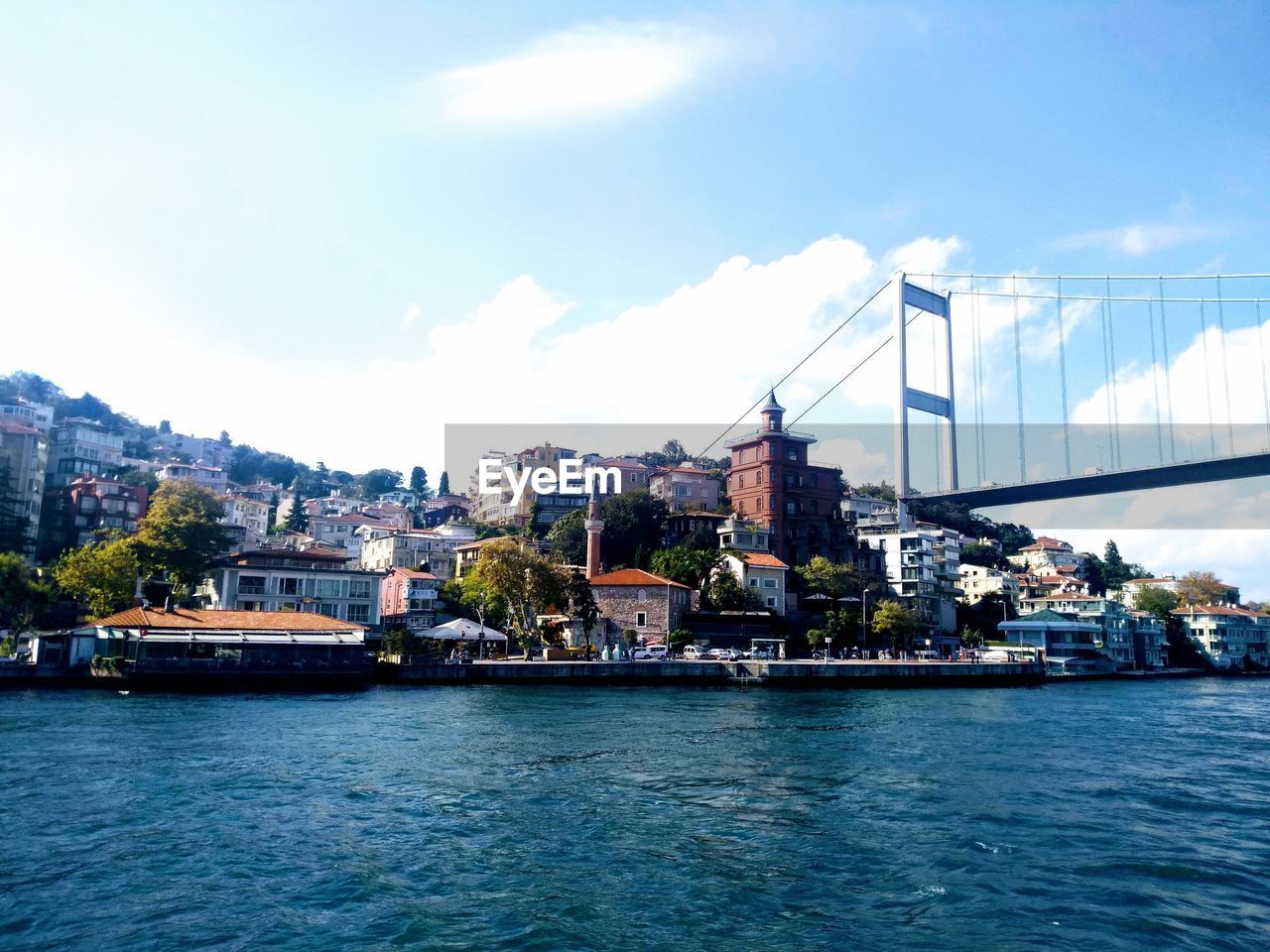 River by buildings in city against sky