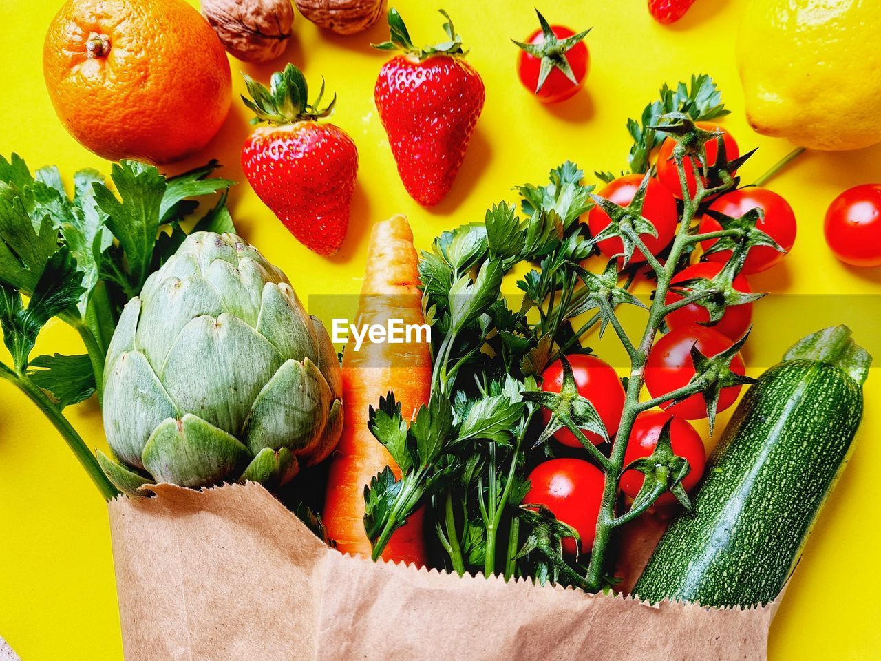 Fruit and vegetables come out of a paper shopping bag