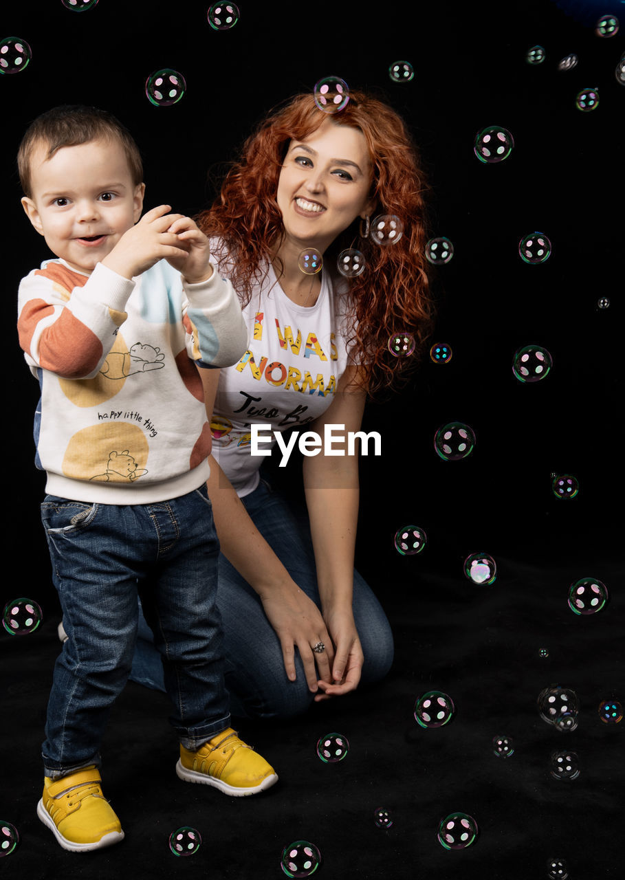 PORTRAIT OF A SMILING GIRL WITH BUBBLES IN CLOTHING